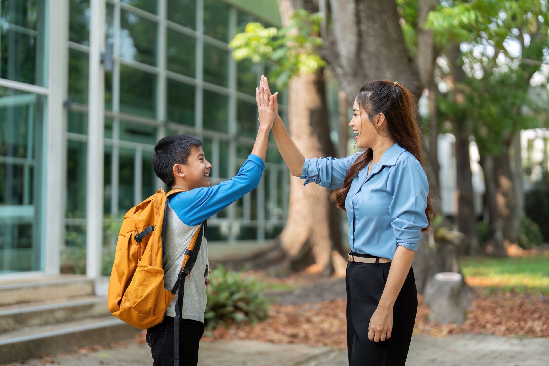 High Fives and Happiness. A mother and son sharing a joyful moment before school.